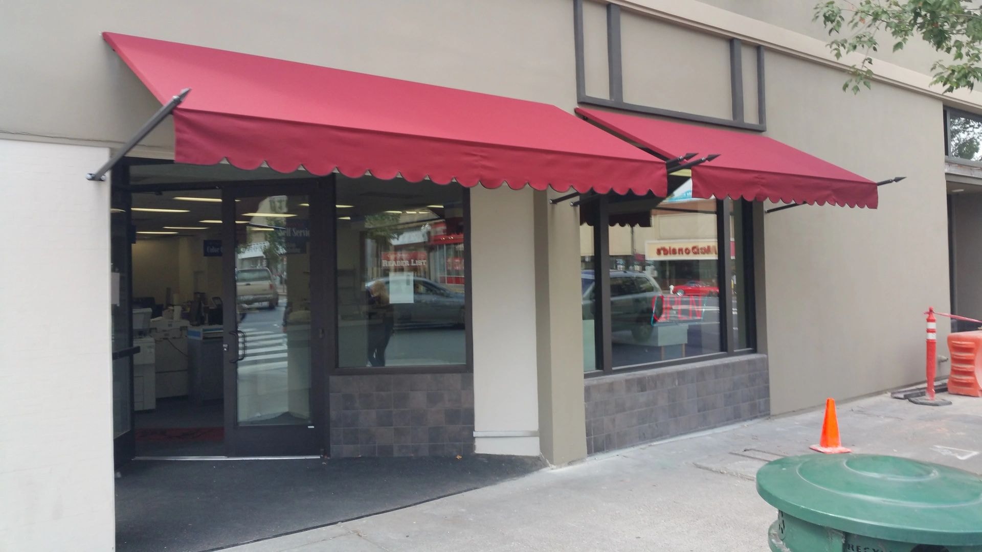 Red retractable awning over storefront